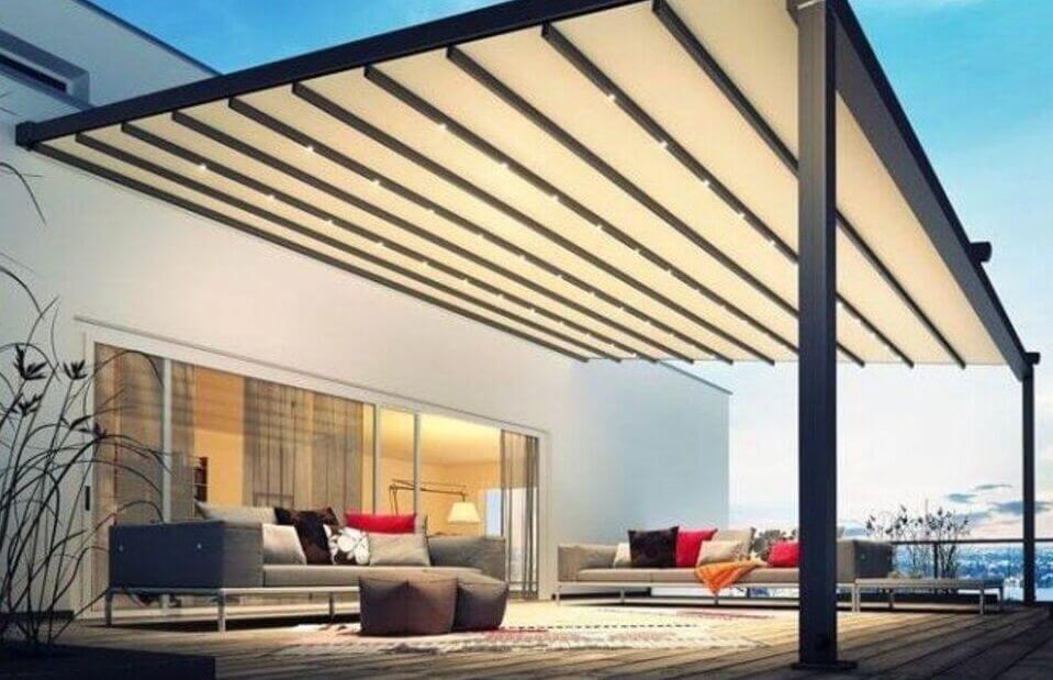 Moderna pergola bioclimatica su un patio con divani e una vista mozzafiato.
