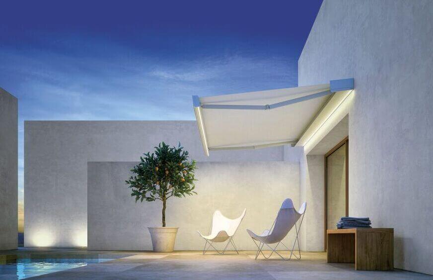 Terrazza moderna con tenda per il sole, piscina, albero di arance e arredi minimalisti.
