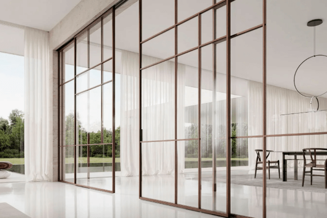 Parete divisoria in vetro con cornice marrone in una moderna sala da pranzo con finestre.