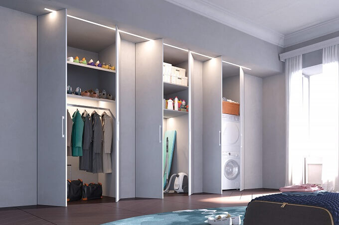 Armadio a muro moderno grigio con ripiani illuminati, vestiti, scarpe e lavatrice.